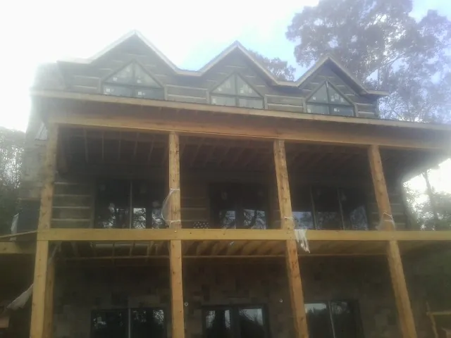 Dormers and porch framing on a large log home under construction — Roof Coating work by our crew in Park Ridge