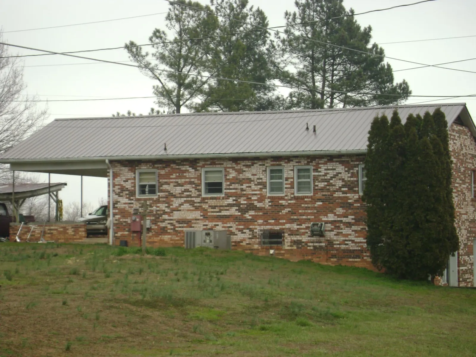 Gray metal roof on a brick split level home with a carport in Park Ridge