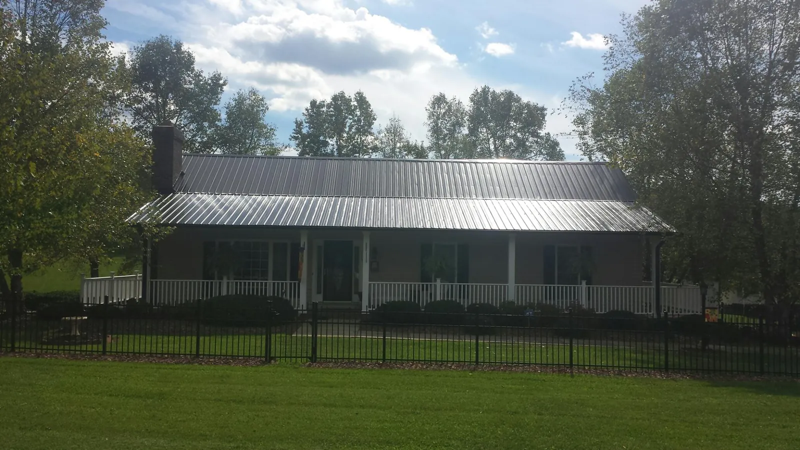 Gray metal roof on a brick ranch with a full width front porch — Gutter Guard Installation work by our crew in Park Ridge